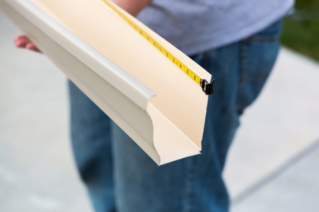 Worker Measuring Rain Gutter Processing Through Seamless Shaping Machine Worker Measuring Rain Gutter Processing Through Seamless Shaping Machine